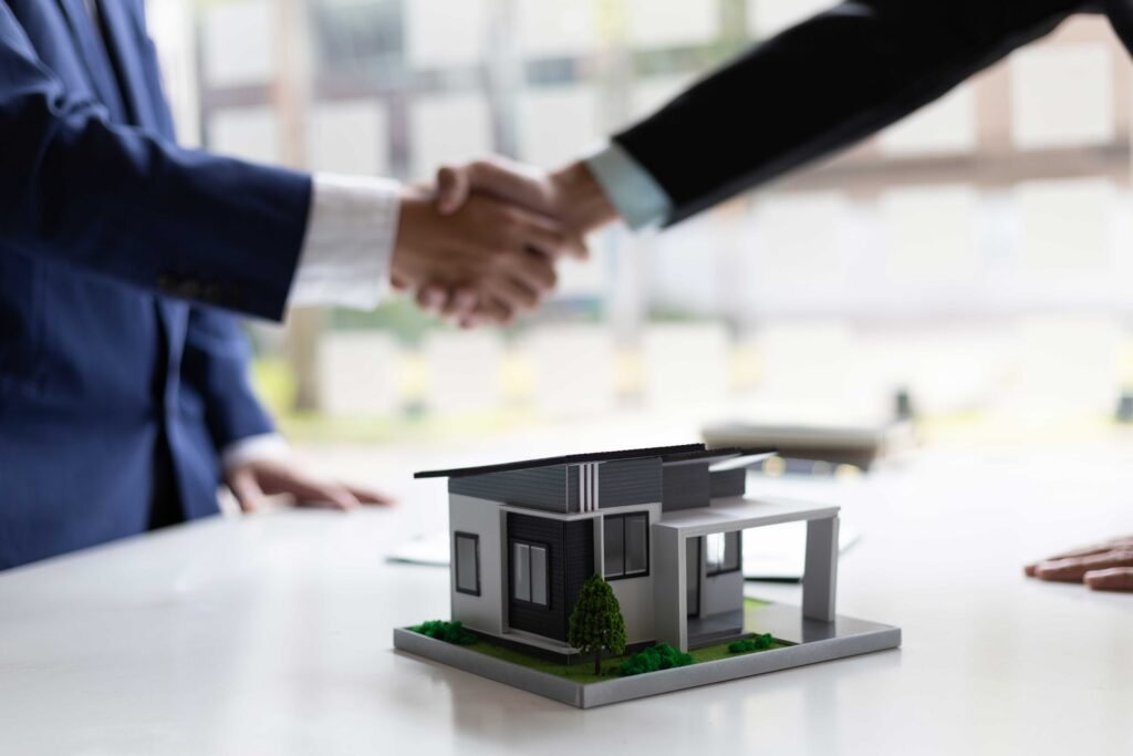 personas tomadas de la mano mientras venden una casa